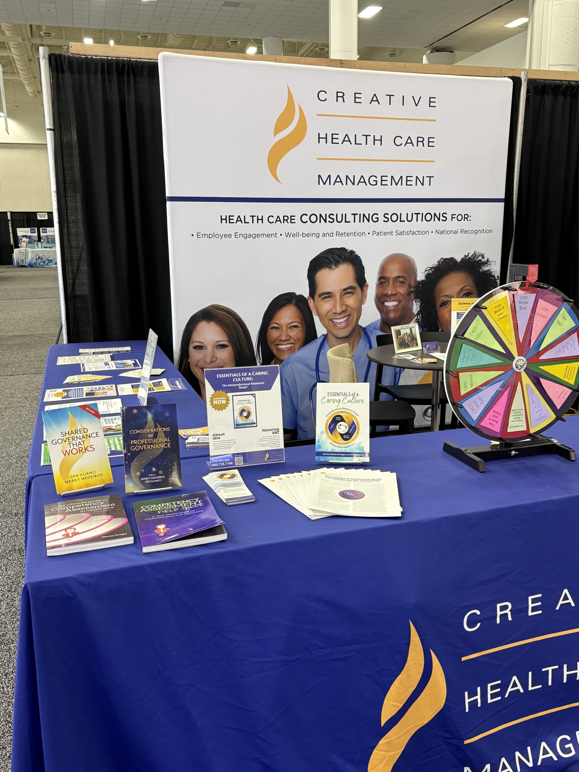•	CHCM team exhibiting at ANPD Aspire Convention booth speaking with nursing professionals | CHCM