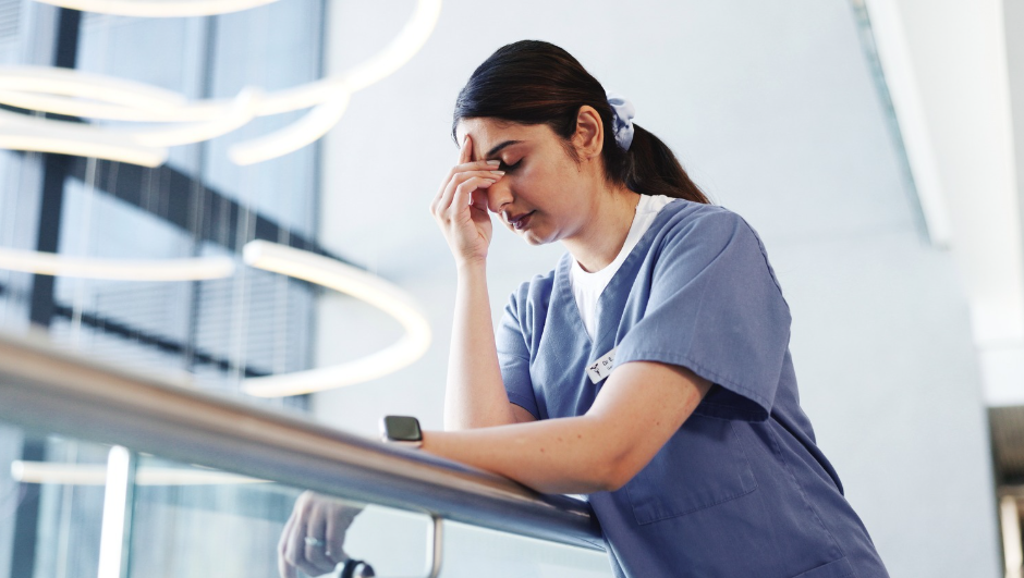 Exhausted nurse sitting in hospital hallway after long clinical shift | CHCM