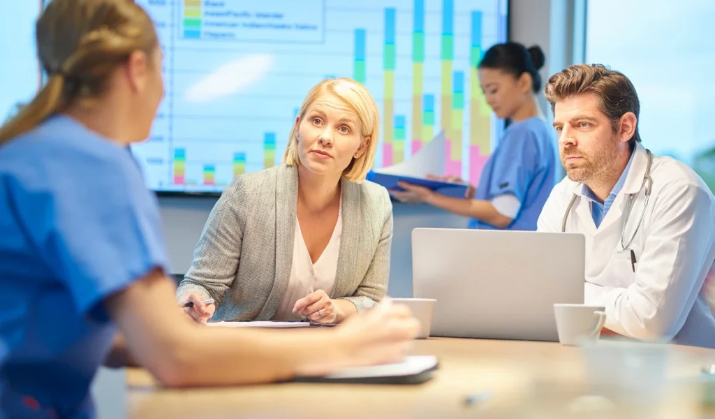 Healthcare team analyzing performance dashboards during a quality improvement meeting | CHCM 