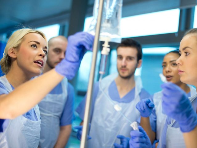 Team of nurses look at an IV bag