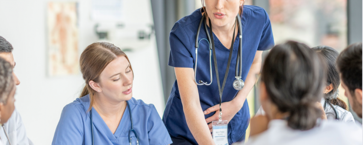 Nurse leading a professional practice discussion with healthcare team members